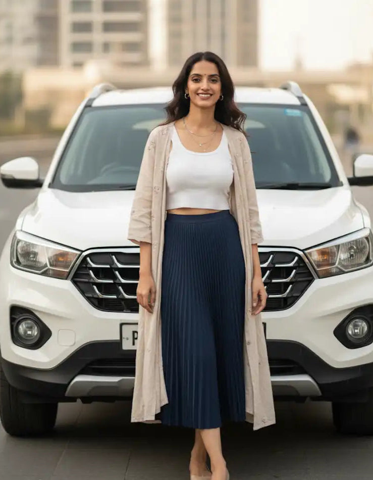 Woman standing in front of a white SUV with a blurred background- madhu Roy founder of urbanzora