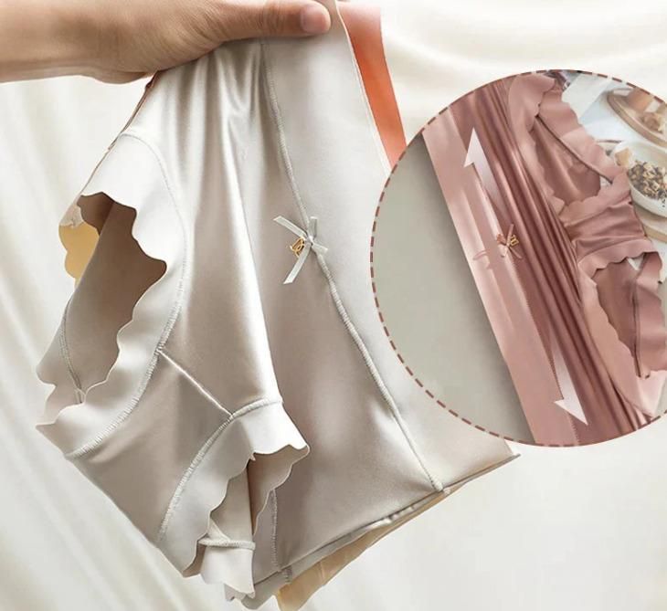 Close-up of a white garment with ruffled details, held by a hand.