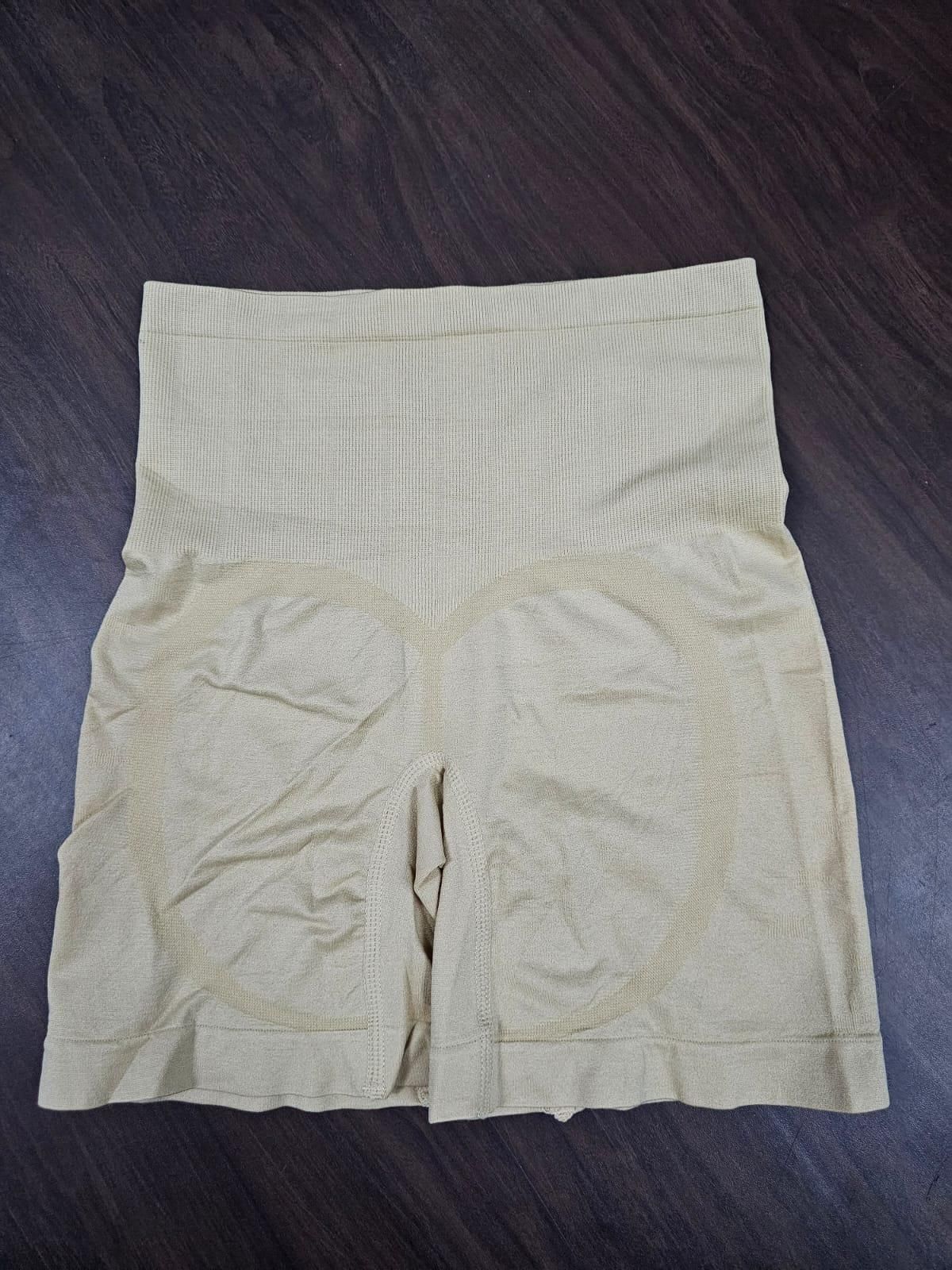 Beige shorts on a dark wooden surface