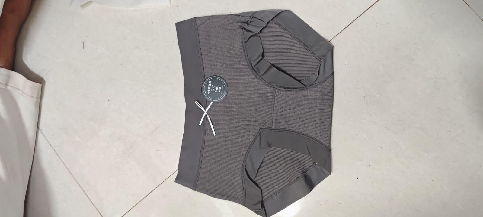 Gray athletic shorts with a logo on a tiled floor